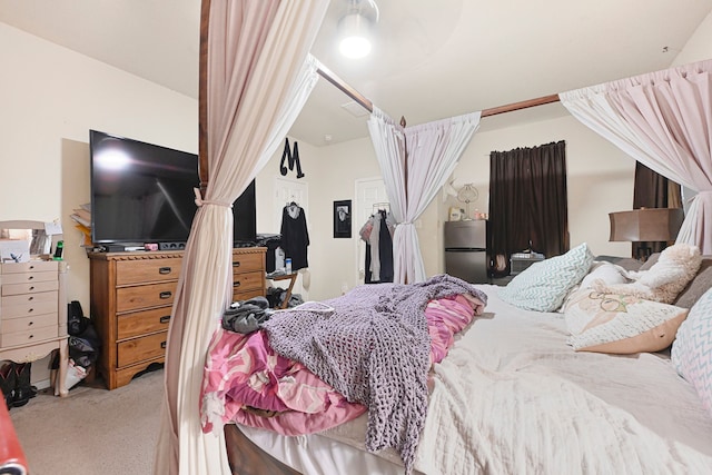 carpeted bedroom featuring freestanding refrigerator