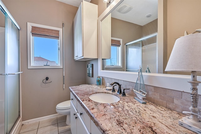 full bath with a stall shower, toilet, vanity, tile patterned floors, and baseboards