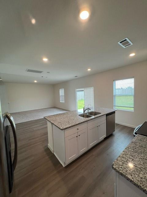 21596 Rolling Streams Dr, New Caney, TX 77357 - kitchen featuring a sink, stainless steel dishwasher, dark wood finished floors, white cabinets, and an island with sink