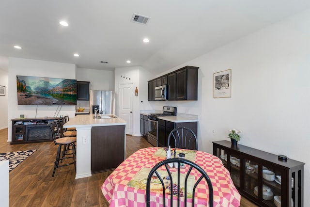 21623 Oakwood Meadows Ln, Katy, TX 77449 - kitchen with stainless steel appliances, a center island with sink, light countertops, dark wood-style floors, and recessed lighting