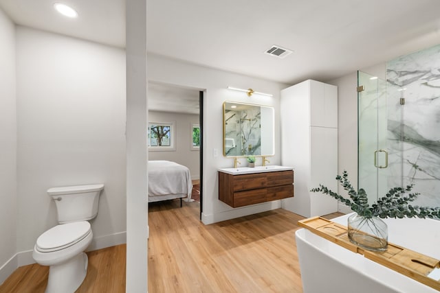 2114 Lazybrook Dr, Houston, TX 77008 - full bath with a marble finish shower, wood finished floors, vanity, toilet, and a freestanding bath