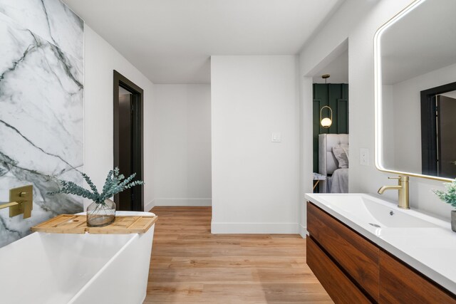 2114 Lazybrook Dr, Houston, TX 77008 - full bathroom with vanity, wood finished floors, a freestanding tub, and baseboards