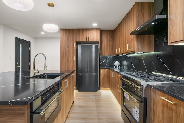 2114 Lazybrook Dr, Houston, TX 77008 - kitchen featuring freestanding refrigerator, high end range, a sink, wall chimney exhaust hood, and brown cabinetry