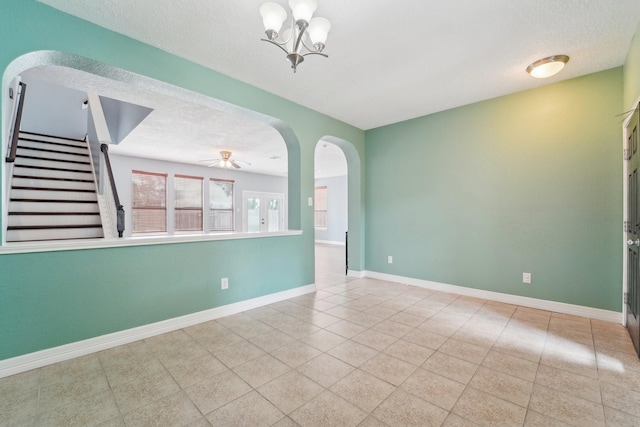 3339 Legends Creek Dr, Spring, TX 77386 - unfurnished room featuring a textured ceiling, arched walkways, tile patterned floors, stairs, and baseboards