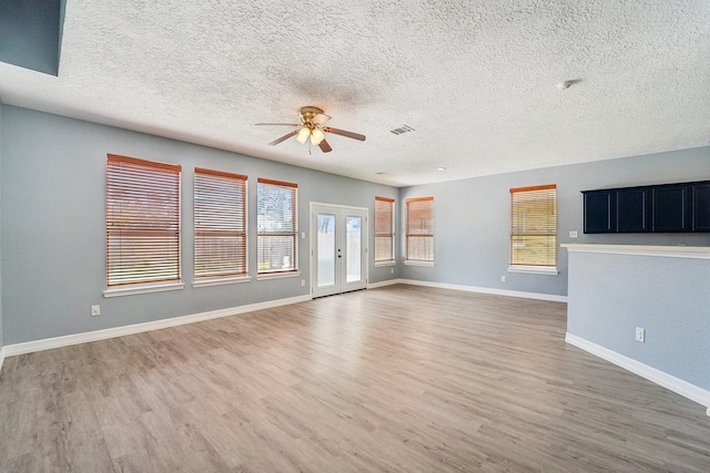 3339 Legends Creek Dr, Spring, TX 77386 - unfurnished living room featuring a ceiling fan, light wood-style flooring, a textured ceiling, and baseboards