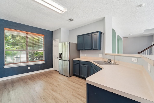 3339 Legends Creek Dr, Spring, TX 77386 - kitchen with stainless steel fridge with ice dispenser, light countertops, light wood-style floors, a sink, and a textured ceiling