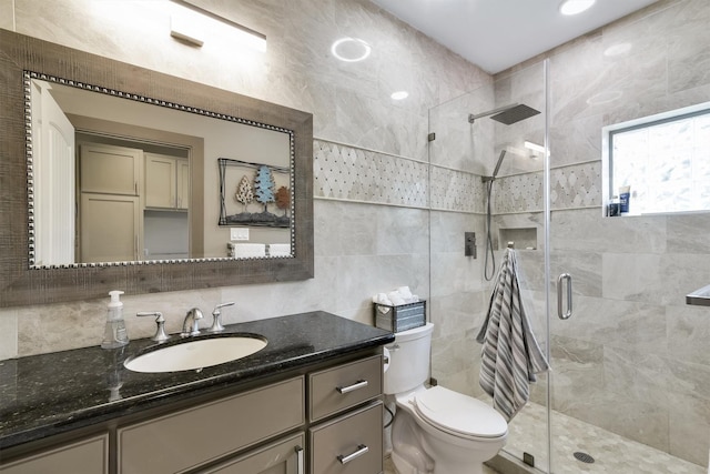 19727 Country Lake Dr, Magnolia, TX 77355 - bathroom featuring tile walls, toilet, a stall shower, vanity, and backsplash