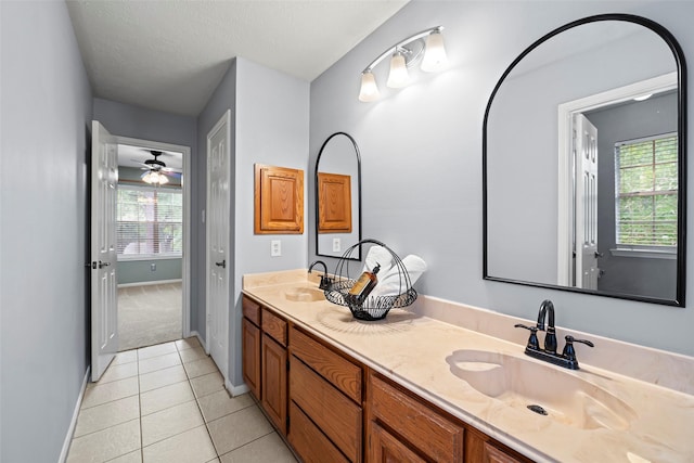 10255 Crooks Way Ct, Houston, TX 77065 - bathroom with tile patterned floors, plenty of natural light, baseboards, double vanity, and a textured ceiling
