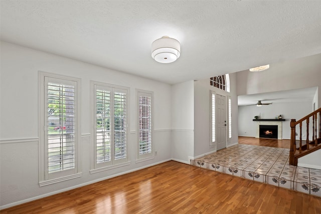 10255 Crooks Way Ct, Houston, TX 77065 - entryway with wood finished floors, a lit fireplace, baseboards, and a textured ceiling