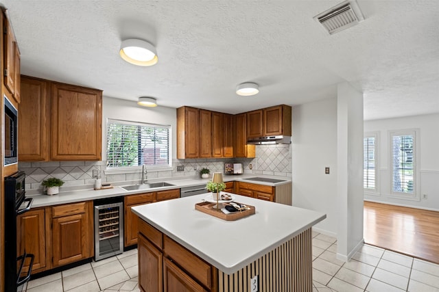 10255 Crooks Way Ct, Houston, TX 77065 - kitchen featuring a sink, beverage cooler, brown cabinets, light tile patterned floors, and backsplash