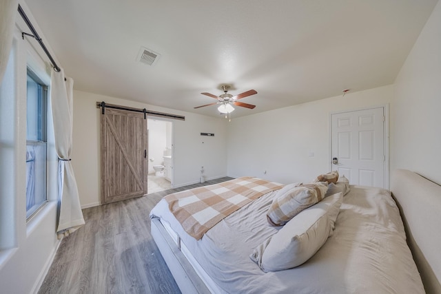 19314 Cactus Thorn Dr, Cypress, TX 77433 - bedroom with a barn door, wood finished floors, baseboards, and multiple windows