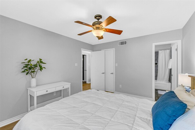 3220 69th St Unit K6, Galveston, TX 77551 - bedroom featuring baseboards, a ceiling fan, and ensuite bath