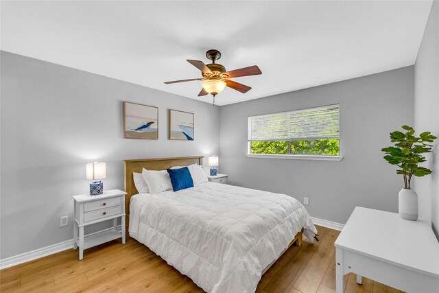 3220 69th St Unit K6, Galveston, TX 77551 - bedroom with baseboards, light wood-style flooring, and ceiling fan