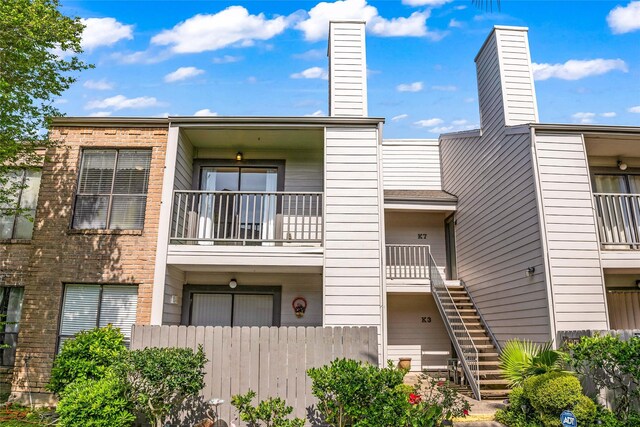 3220 69th St Unit K6, Galveston, TX 77551 - view of building exterior featuring fence and stairway