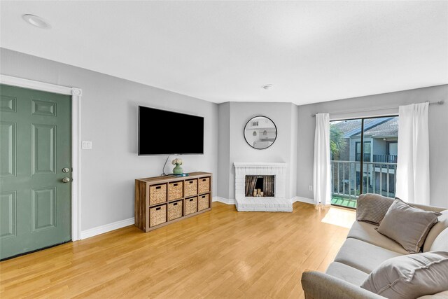 3220 69th St Unit K6, Galveston, TX 77551 - living room with light wood-style flooring, baseboards, and a fireplace