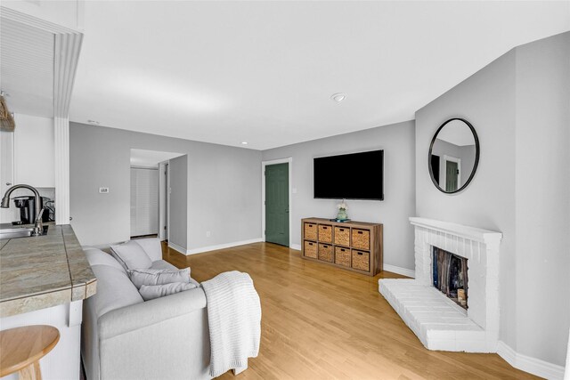 3220 69th St Unit K6, Galveston, TX 77551 - living room with light wood-style floors, a fireplace, baseboards, and recessed lighting