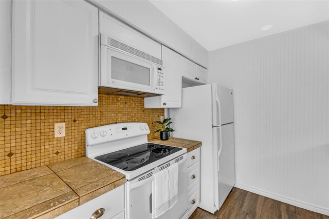 3220 69th St Unit K6, Galveston, TX 77551 - kitchen with white appliances, white cabinets, dark wood-type flooring, tasteful backsplash, and tile counters