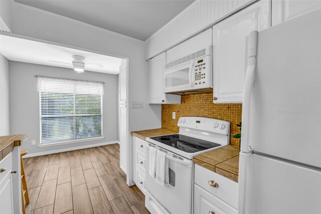 3220 69th St Unit K6, Galveston, TX 77551 - kitchen featuring white appliances, white cabinets, decorative backsplash, light wood finished floors, and baseboards