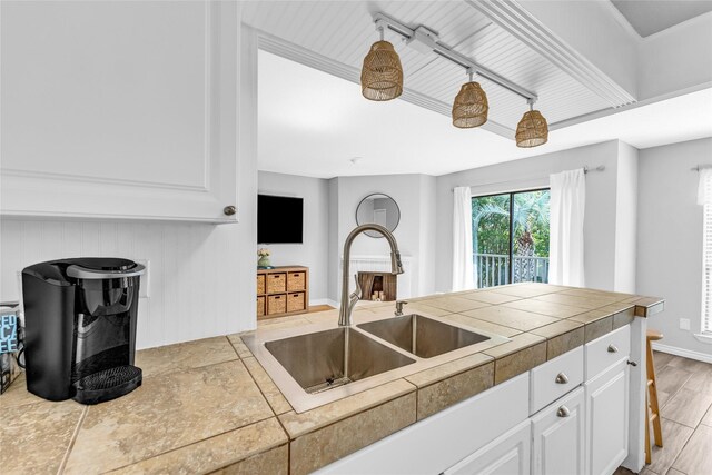 3220 69th St Unit K6, Galveston, TX 77551 - kitchen featuring a sink, white cabinetry, and baseboards