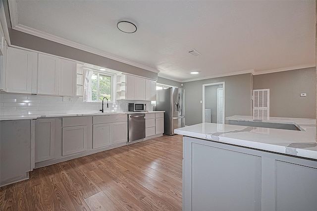 11903 Atwell Dr, Houston, TX 77035 - kitchen featuring stainless steel appliances, crown molding, light wood finished floors, tasteful backsplash, and a sink