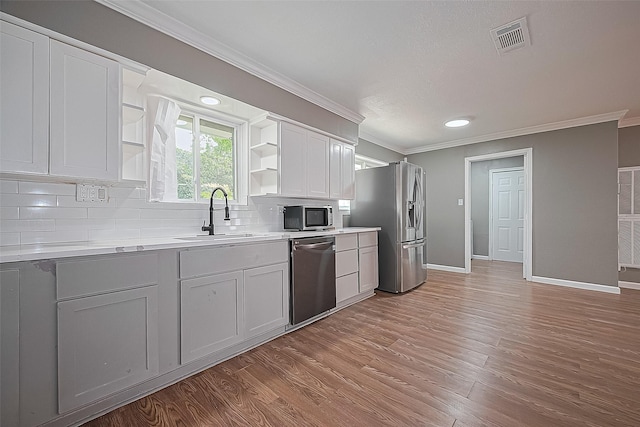 11903 Atwell Dr, Houston, TX 77035 - kitchen with appliances with stainless steel finishes, open shelves, a sink, ornamental molding, and backsplash