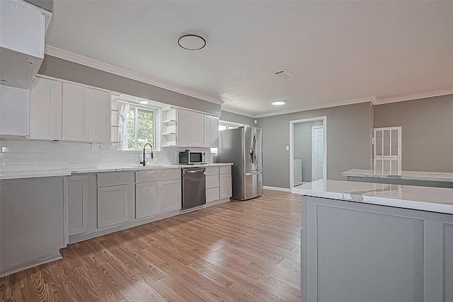 11903 Atwell Dr, Houston, TX 77035 - kitchen featuring stainless steel appliances, ornamental molding, a sink, light wood finished floors, and light countertops