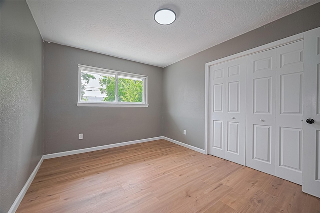 11903 Atwell Dr, Houston, TX 77035 - unfurnished bedroom featuring a textured ceiling, light wood finished floors, a closet, and baseboards