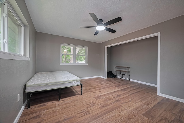 11903 Atwell Dr, Houston, TX 77035 - bedroom featuring wood finished floors, a textured ceiling, baseboards, and ceiling fan