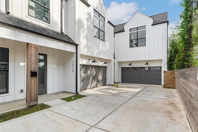 1412 Weiss St, Houston, TX 77009 - view of front of home with a shingled roof, an attached garage, board and batten siding, driveway, and fence