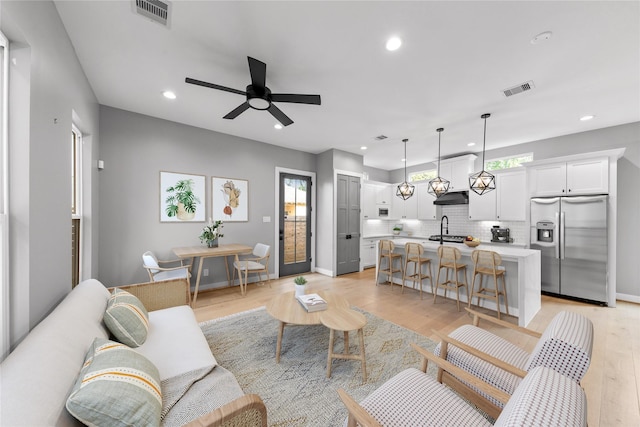 1412 Weiss St, Houston, TX 77009 - living area with light wood finished floors, ceiling fan, recessed lighting, and baseboards