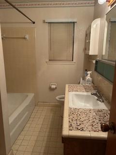 5005 Oak Ln, Texas City, TX 77591 - bathroom with vanity, toilet, bathtub / shower combination, baseboards, and tile patterned flooring