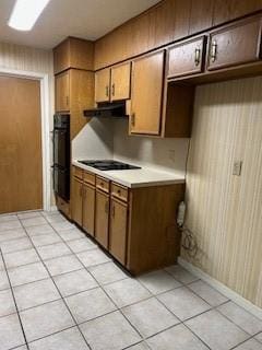 5005 Oak Ln, Texas City, TX 77591 - kitchen with black appliances, light countertops, light tile patterned floors, under cabinet range hood, and brown cabinets
