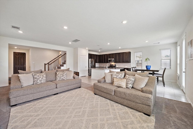 17303 Rock Willow Ln, Tomball, TX 77377 - living area featuring stairs, recessed lighting, light tile patterned floors, baseboards, and light colored carpet