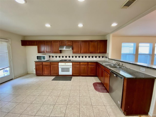 9414 Glendown Ln, Houston, TX 77070 - kitchen with stainless steel appliances, a sink, tasteful backsplash, under cabinet range hood, and healthy amount of natural light