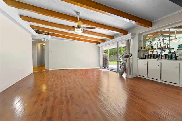3641 Deal St, Houston, TX 77025 - unfurnished living room with beam ceiling, a ceiling fan, wood finished floors, a bar, and baseboards