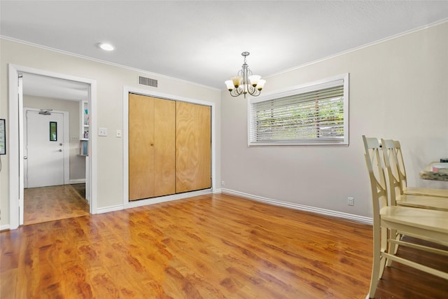 3641 Deal St, Houston, TX 77025 - unfurnished bedroom featuring crown molding, a chandelier, wood finished floors, a closet, and baseboards