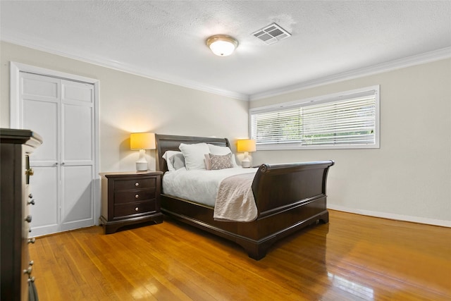 3641 Deal St, Houston, TX 77025 - bedroom with hardwood / wood-style flooring, crown molding, a textured ceiling, and baseboards