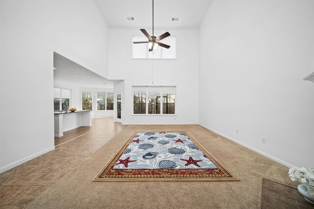 4663 Rockton Hills Ln, Sugar Land, TX 77479 - unfurnished living room with ceiling fan, baseboards, carpet, and a towering ceiling