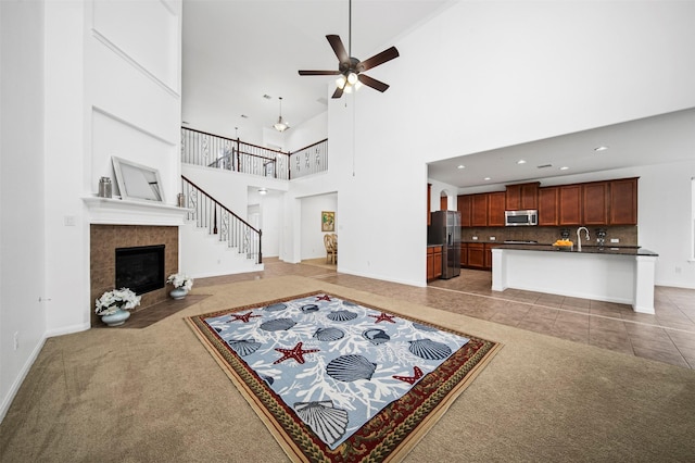 4663 Rockton Hills Ln, Sugar Land, TX 77479 - living area with light colored carpet, ceiling fan, a fireplace, a high ceiling, and baseboards