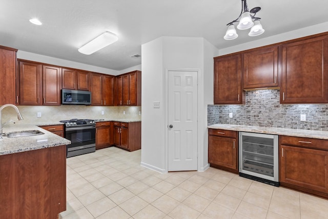 kitchen featuring stainless steel microwave, a sink, gas stove, wine cooler, and light stone countertops