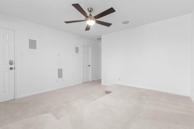 unfurnished room featuring light carpet, a ceiling fan, and baseboards