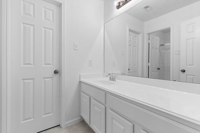 full bathroom with tile patterned flooring, vanity, baseboards, and a shower