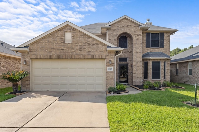 traditional-style home with concrete driveway, a front yard, a garage, and brick siding