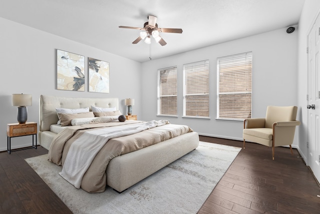 bedroom featuring dark wood-type flooring, baseboards, and a ceiling fan