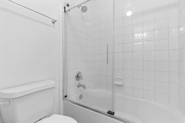 full bathroom with toilet and shower / bath combination with glass door