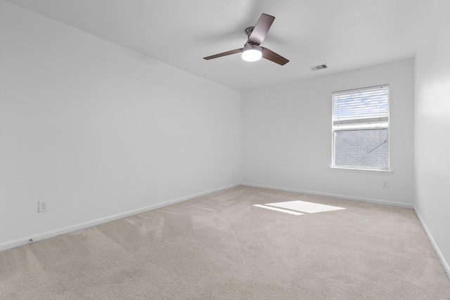 carpeted spare room with ceiling fan and baseboards