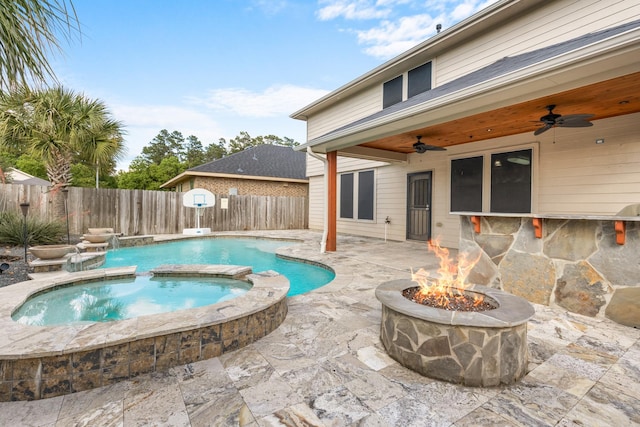 view of pool with ceiling fan, a fire pit, a fenced backyard, a patio, and a pool with connected hot tub