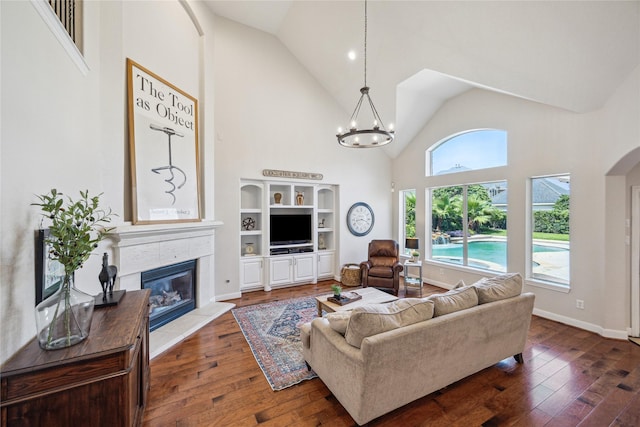 6338 Collina Springs Ct, Houston, TX 77041 - living room with high vaulted ceiling, dark wood finished floors, a glass covered fireplace, a chandelier, and baseboards