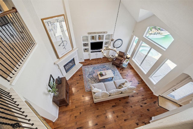 6338 Collina Springs Ct, Houston, TX 77041 - living area featuring a high ceiling, a glass covered fireplace, hardwood / wood-style floors, stairway, and a chandelier