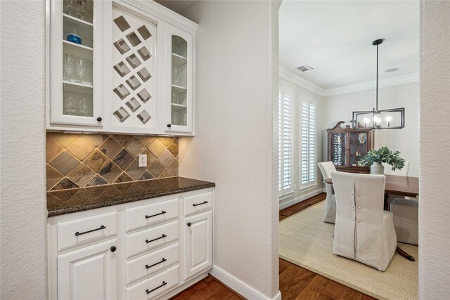 6338 Collina Springs Ct, Houston, TX 77041 - bar featuring dark wood-style floors, a chandelier, crown molding, tasteful backsplash, and pendant lighting